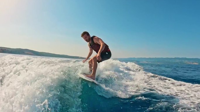 男子骑滑水板，在蔚蓝的天空下享受海浪