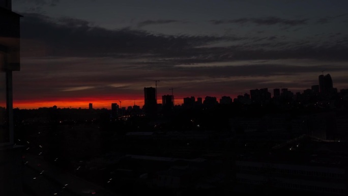 夕阳与橘红色的天空在城市景观与建筑物的剪影。夕阳在大城市的背景下