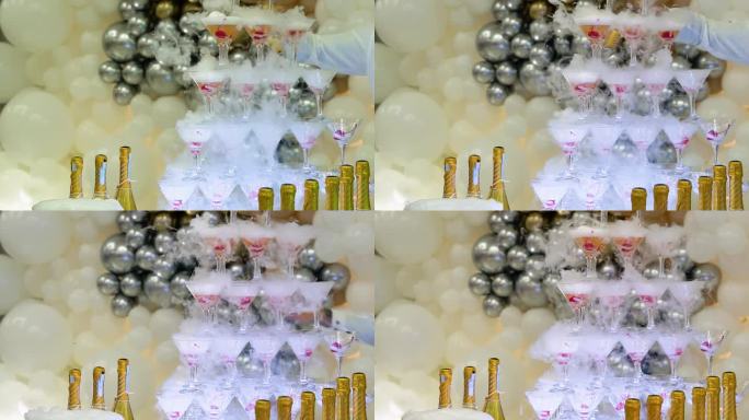 婚礼上的香槟酒杯立在高高的塔里。香槟玻璃金字塔。金字塔般的酒杯，香槟，香槟塔。晚上的婚礼