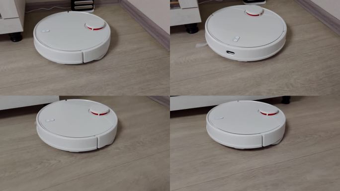 一个现代的白色机器人吸尘器在家里清理地板上的灰尘。电子助理打扫房间，做家务
