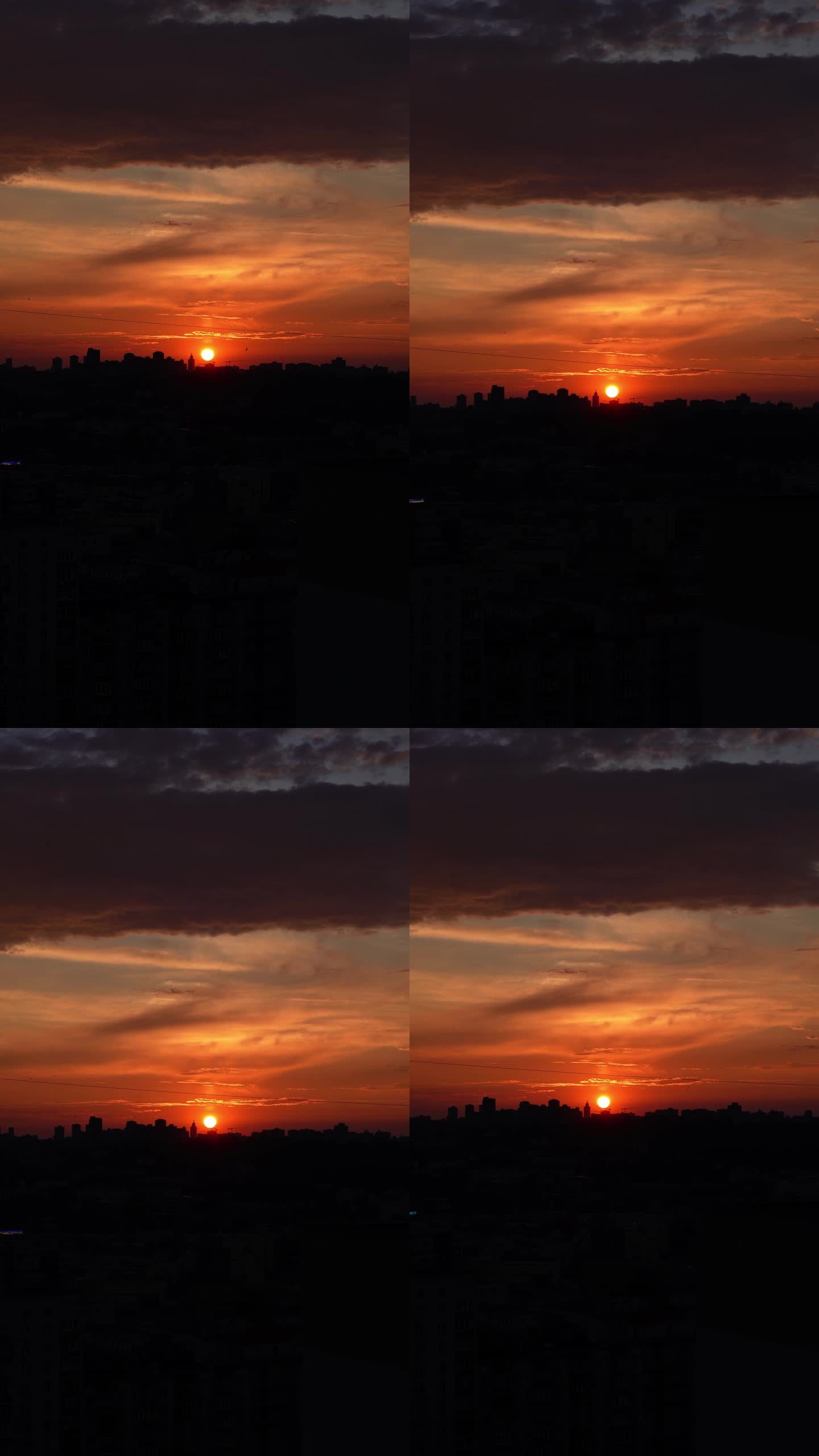夕阳在大城市的背景下。夕阳与橘红色的天空在城市景观与建筑物的剪影