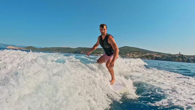 SLO MO男子熟练地骑滑水板，庆祝海上冒险在阳光明媚的一天