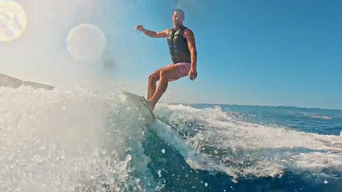 SLO MO -时间扭曲效果/速度坡道男子享受滑水冒险与凉爽的动作在阳光海浪
