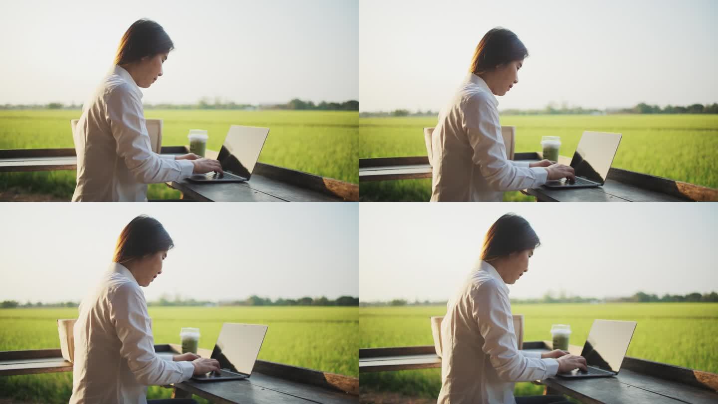 妇女使用笔记本电脑远程工作在稻田在农村地区，自由数字游牧民