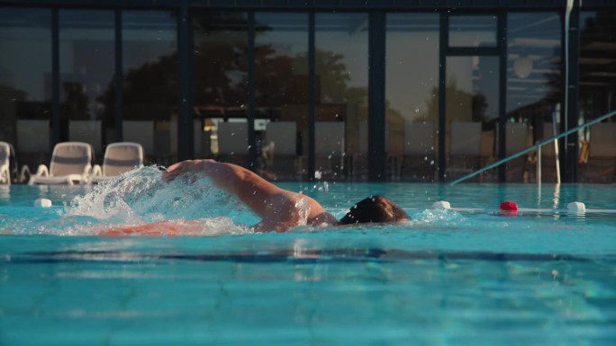 戴泳镜的男子运动员在度假村泳池准备练习
