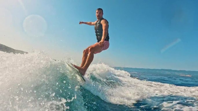 SLO MO -时间扭曲效果令人兴奋的男子冲浪与滑水板在波光粼粼的大海在阳光下