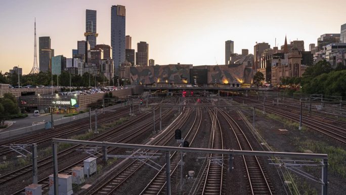 澳大利亚维多利亚州墨尔本，墨尔本现代大厦上空的火车交通与云层的昼夜延时