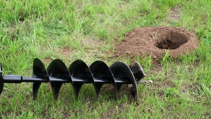 钻过的地面。陆地洞。用于围栏安装的钻孔机。生工具。便携式手动挖土钻机，用于准备种植灌木或树木所需的土
