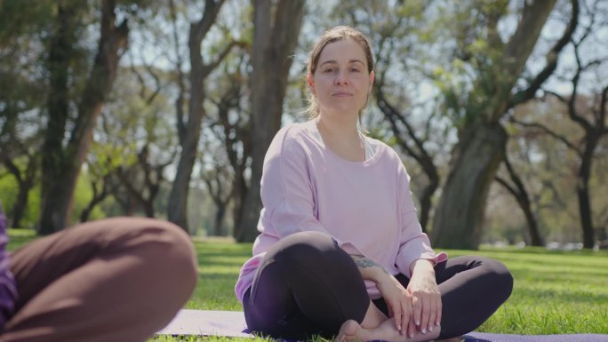在公园瑜伽课上摆姿势拍照的快乐女人