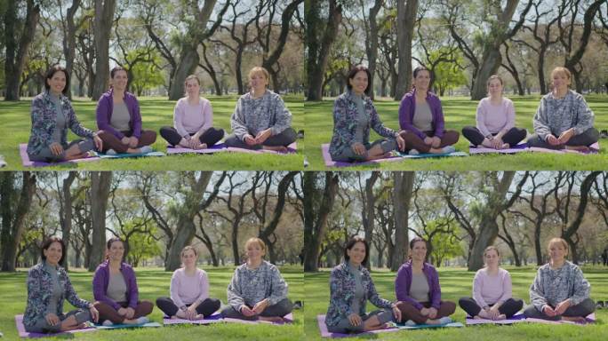 一群快乐的女性在户外瑜伽练习时对着相机摆姿势
