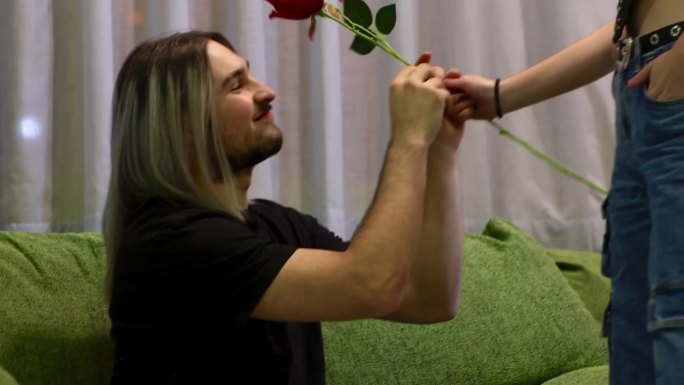 女友在家给男友送玫瑰的视频。一个女孩在情人节给她的男朋友一朵玫瑰。