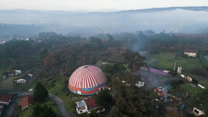 一架无人机在班波斯特马戏团的帐篷上空升起，树冠上笼罩着薄雾