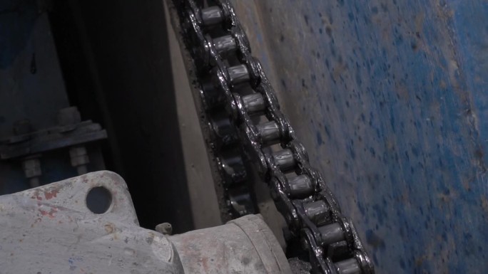 一个链条旋转着一个巨大的钢鼓，机械机器的特写