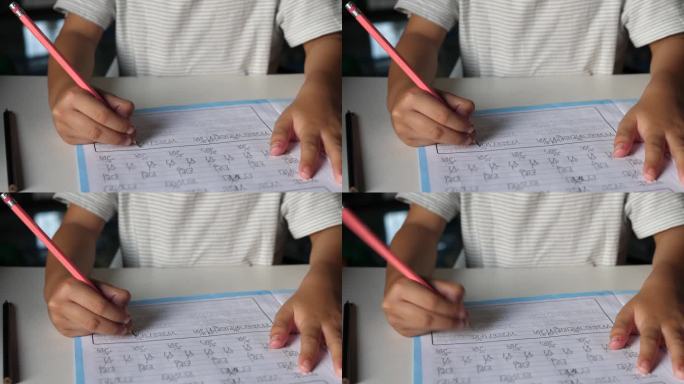 图为小学生在练习本上写字。亚洲男孩在家做作业，坐在书桌前。教育理念，学习，家校。