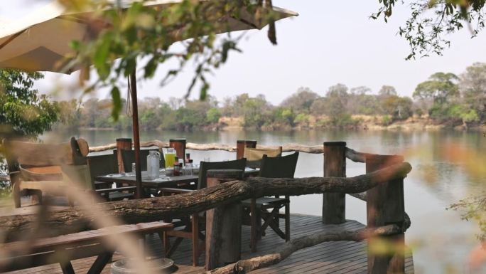 放松身心，从卡富埃河的甲板上欣赏美景。木桌和长凳，可以看到河边的美景。