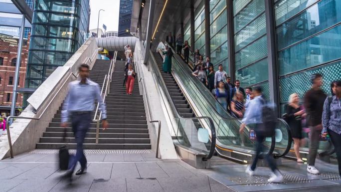 澳大利亚新南威尔士州悉尼市区，上午高峰时段，拥挤的商务人员和乘客通过楼梯和自动扶梯上下走动到现代办公