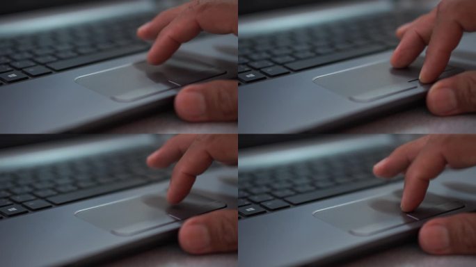 一个男人用笔记本电脑的手特写。