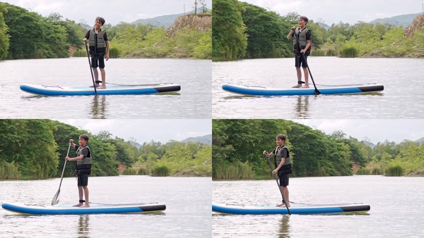 亚洲运动新秀在湖边学习玩桨板。暑假单人户外水上运动和旅游。