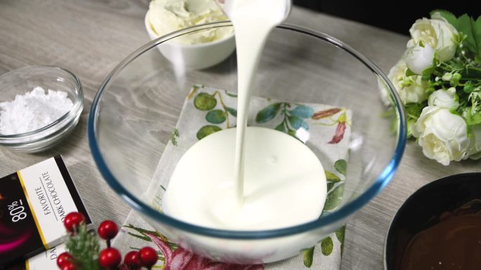 向碗中加入牛奶奶油。牛奶倒进碗里，特写。烘焙原料。