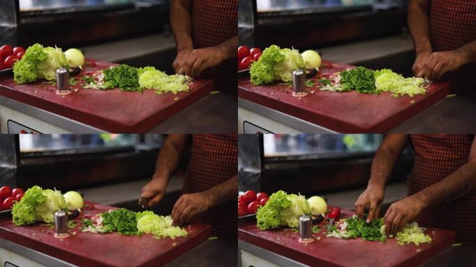 一名土耳其男子在厨房里切新鲜的卷心菜和生菜——传统的可可豆沙拉