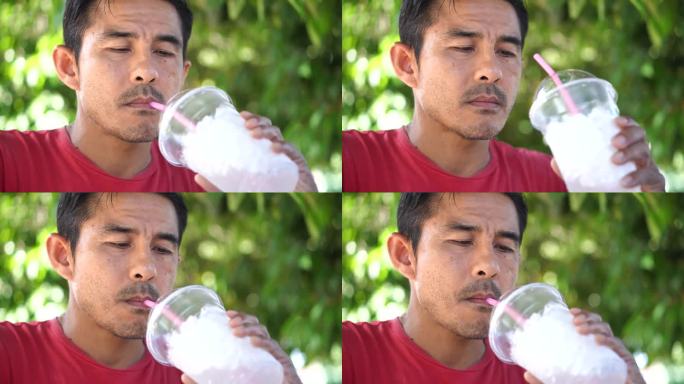 一个男人用一根吸管从杯子里喝水。