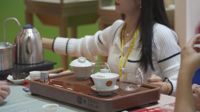 茶博会上的女茶艺师在泡茶给宾客饮用