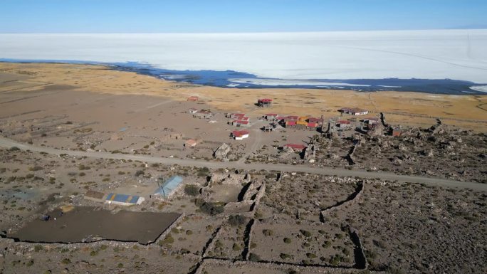 从玻利维亚的乌尤尼盐湖的村庄向后飞行