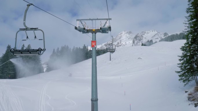 在瑞士布伦尼的恩格尔贝格滑雪胜地，升降椅和冰上飞行器在雪山上上下移动。