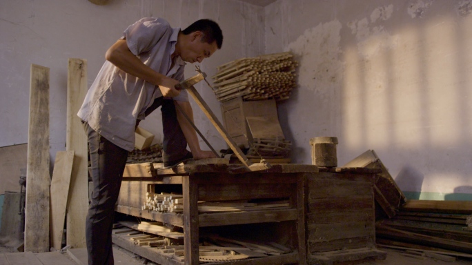 木匠在小作坊锯木头加工家具
