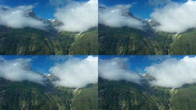 泛动飞行揭示了厚厚的云层覆盖的山顶和瀑布从森林覆盖的斜坡上冲下来。