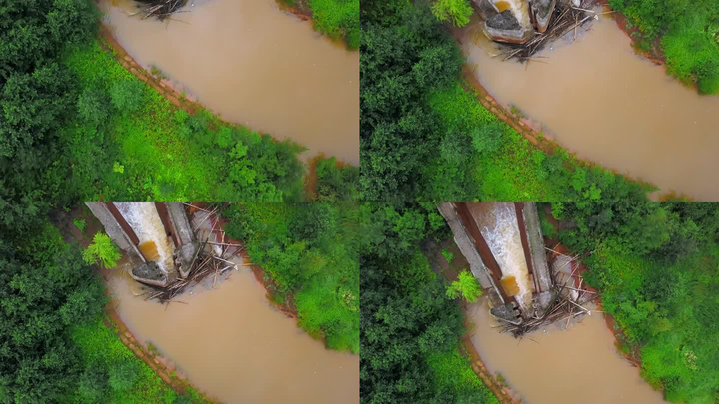 脏河上水坝的俯视图。夹。脏河上的工业水坝。大坝或大坝在棕色河流与绿色森林的床上