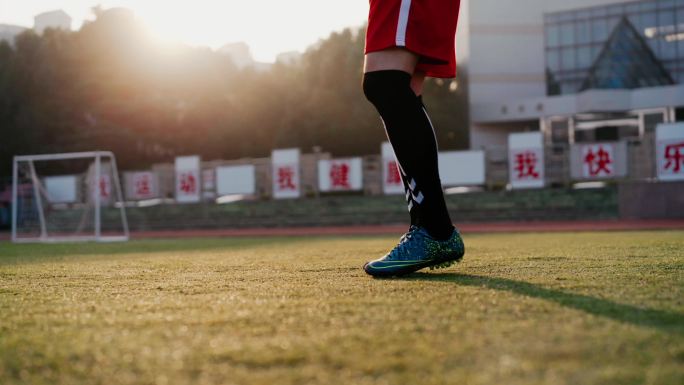 运动员学校踢足球训练夕阳宣传片逆光草坪