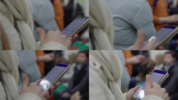 土耳其伊斯坦布尔，一名妇女在地铁上使用智能手机的手持照片