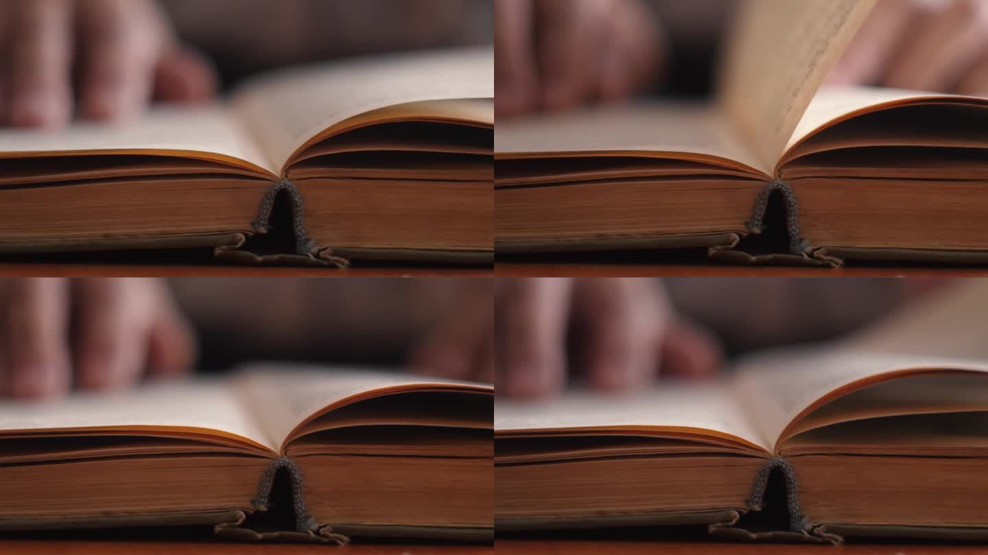 一个人的手翻动着一页发黄的旧书的特写镜头。有选择性的重点。休闲读书。老人手里的旧书