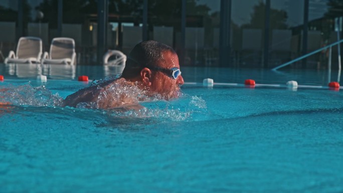 在健身俱乐部的游泳池里，超级熟练的男子顺利地掌握蝶泳