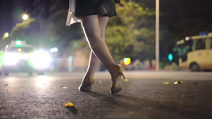 女人夜晚穿高跟鞋走路