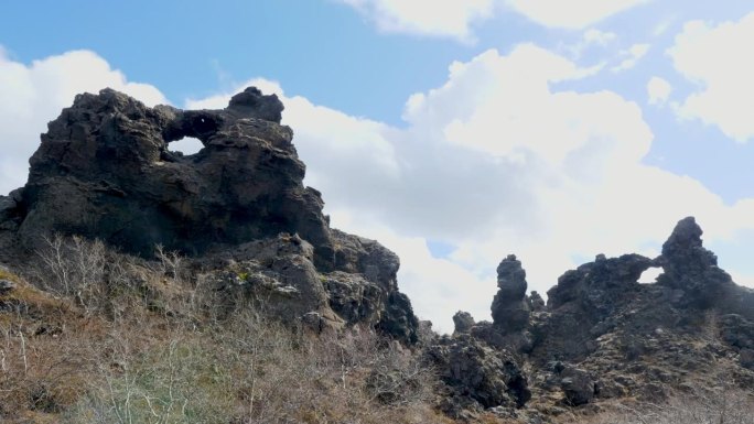 冰岛Dimmuborgir崎岖的熔岩形成的时间流逝，展示了多云天空下大自然的艺术