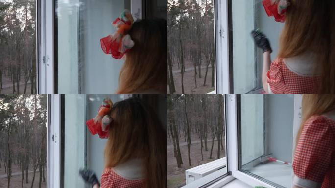 一个穿着红裙子打着蝴蝶结的女孩在擦窗户上的灰尘。