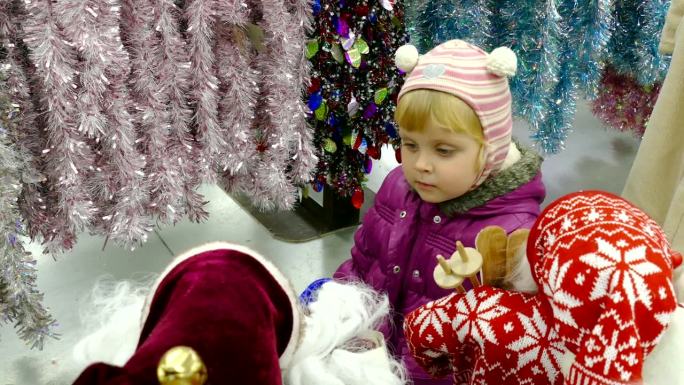 小女孩和圣诞老人一起看展示柜