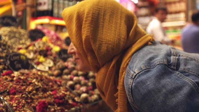 在伊斯坦布尔大巴扎，一名女游客陶醉在干茶叶的香气中