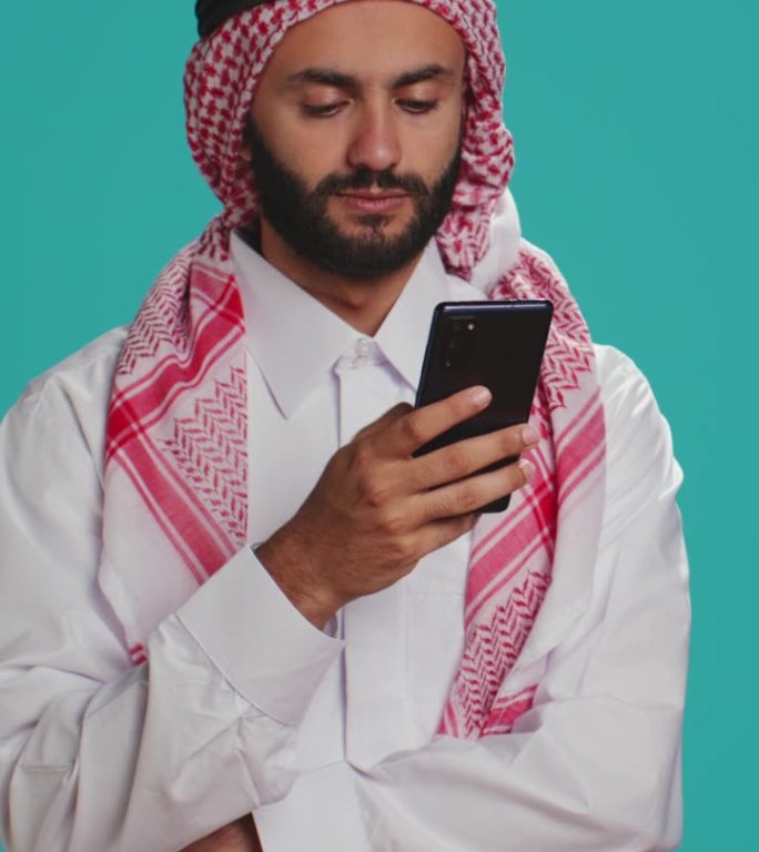 垂直视频穆斯林男子穿着服装使用智能手机