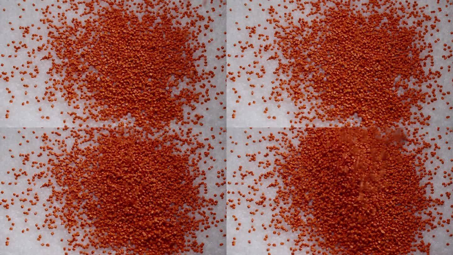 宏观框架的白色和橙色塑料颗粒。将聚合物复合材料倒入罐中，用于进一步生产和在特殊模具中铸造。生产