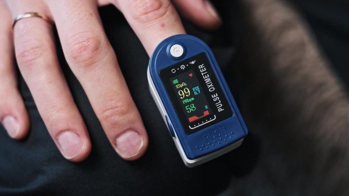 男子在家用脉搏血氧仪测量脉搏和血氧饱和度。