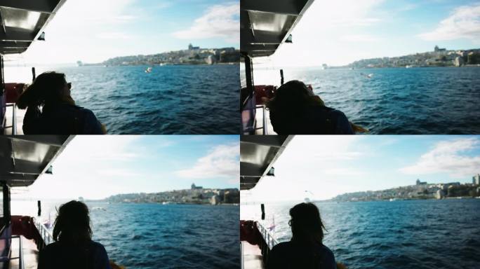女子在博斯普鲁斯海峡游船上，感受清风，欣赏美景
