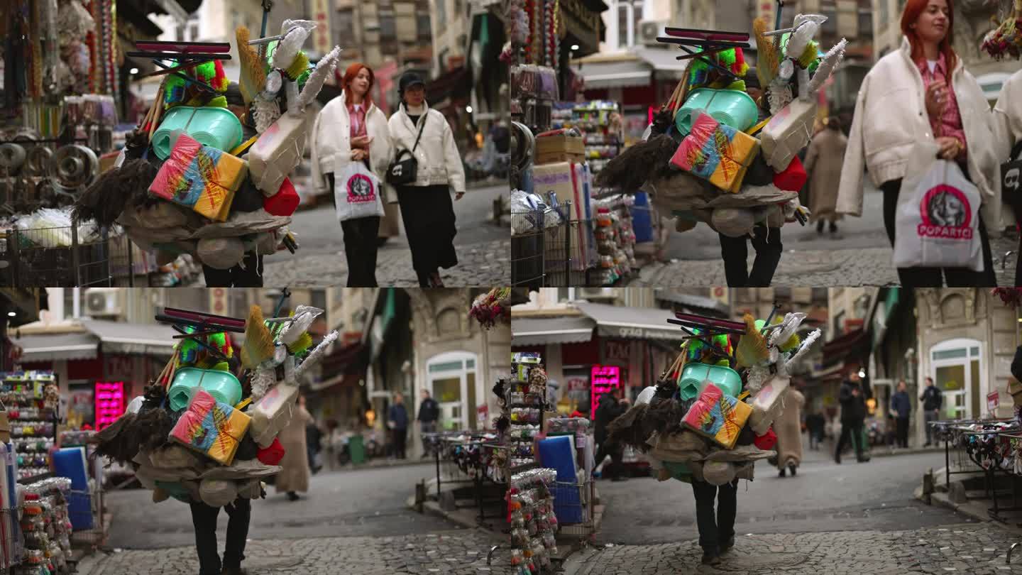 土耳其伊斯坦布尔，一名男子走在街上卖家用工具的手持镜头