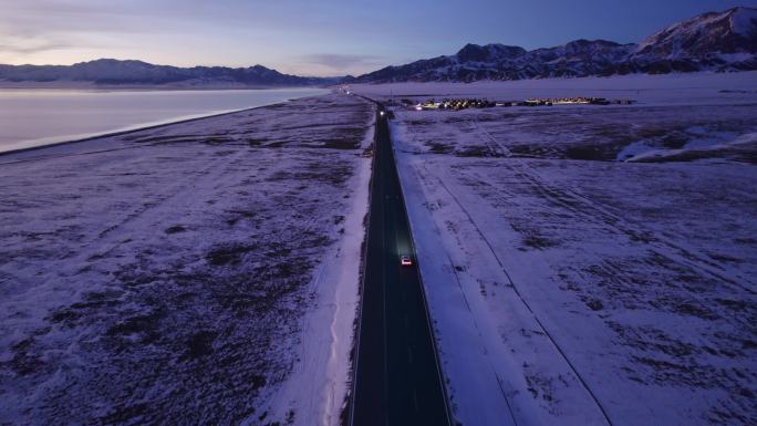 傍晚行驶在雪地公路的汽车