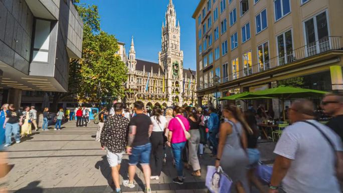 德国巴伐利亚州慕尼黑，夏季，游客在慕尼黑市中心的中心广场Marienplatz和新市政厅散步和观光景