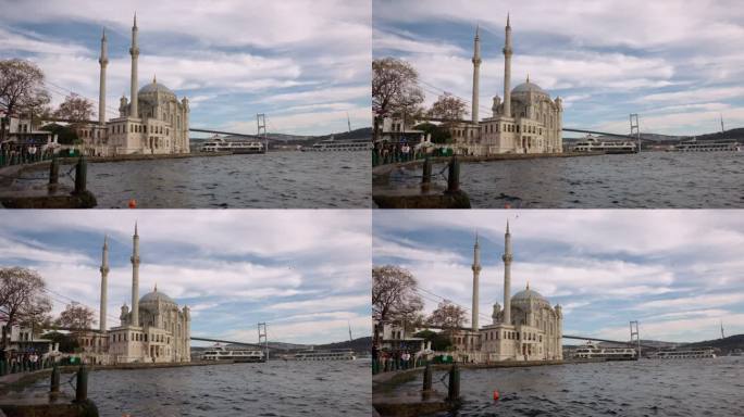 手持拍摄的Ortakoy清真寺和博斯普鲁斯大桥在海上对多云的天空在伊斯坦布尔，土耳其