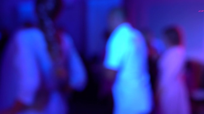 在霓虹灯下跳舞的女人和男人，模糊的视频。