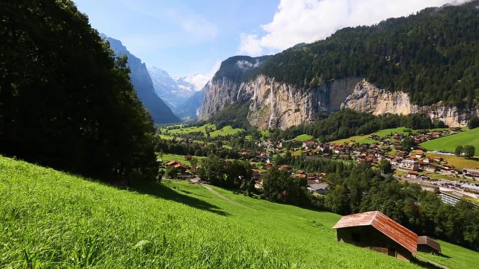 在一个阳光明媚的日子里，看到高山清新的绿色草地。Lauterbrunnen valley, Stau